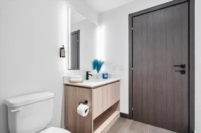 a bathroom with a toilet and a sink with a wooden door at MVR - If You Want the Best Views Stay Here in Miami