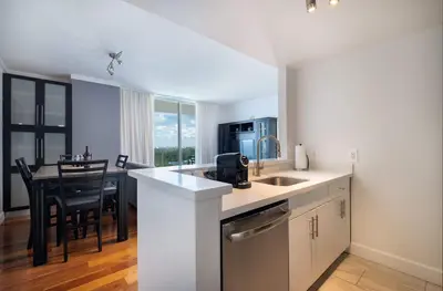 a kitchen with a sink and a table with chairs at MVR - Stay Near Brickell Without the Hassle in Miami