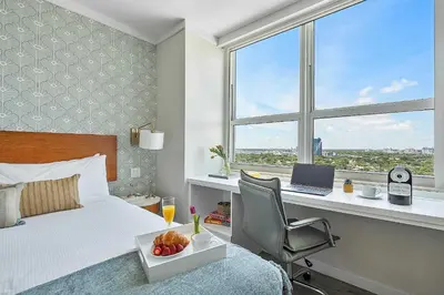 a bedroom with a bed and a desk with a laptop at MVR - Rooftop Access Rooms-Almost Gone in Miami