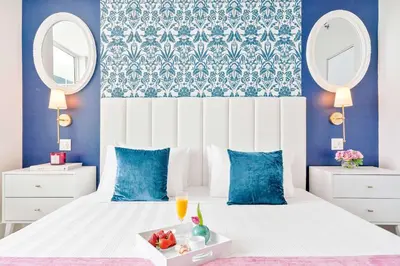 a bedroom with a white bed with blue walls and mirrors at MVR - Your Private Slice of Grove Luxury Awaits in Miami