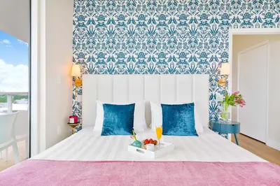 a bedroom with a white bed with blue and white walls at MVR - Stop Searching-This Grove Stay Has It All in Miami