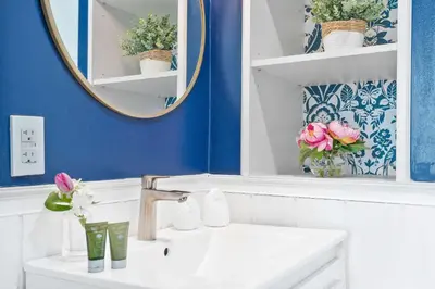 a bathroom with a sink and a mirror and flowers at MVR - Stop Searching-This Grove Stay Has It All in Miami