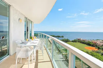 a balcony with a table and chairs and the ocean at MVR - Skyline Dreams from Your Private Balcony in Miami
