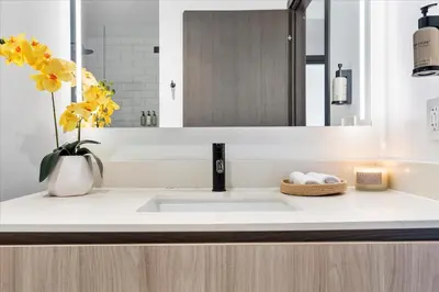 a bathroom sink with a vase of flowers and a mirror at MVR - Swim Relax & Enjoy Jaw-Dropping Views in Miami