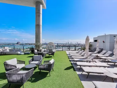 a row of lounge chairs on the roof of a building at MVR - 5-Star Resort Pool & Private Balcony in Miami