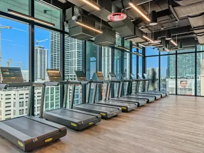 a gym with a row of beds in a room with windows at MVR - Designer Apt with Jaw-Dropping Views & Pool in Miami