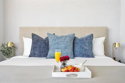 a bed with a tray of fruit and a glass of orange juice at MVR - Best Views in Downtown - Walk Everywhere in Miami