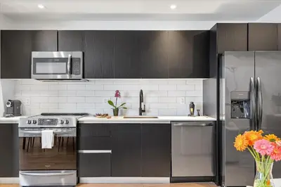 a kitchen with black cabinets and a stainless steel refrigerator at MVR - Best Views in Downtown - Walk Everywhere in Miami
