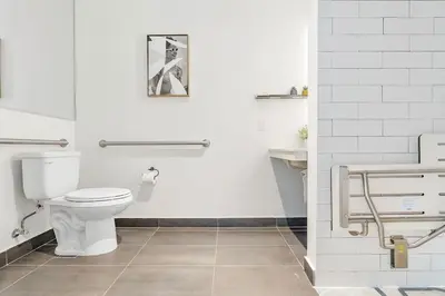 a white bathroom with a toilet and a sink at MVR - VIP Pool Deck & Rooftop Lounge Access in Miami