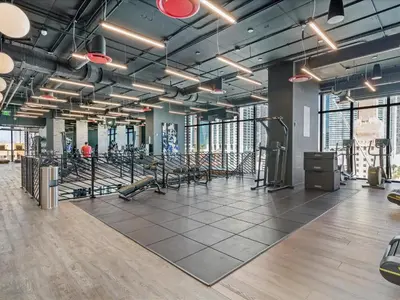 a gym with rows of exercise equipment in a building at MVR - VIP Pool Deck & Rooftop Lounge Access in Miami