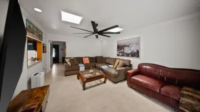 a living room with couches and a ceiling fan at Luxury Queen Room, Walk to UM, Free Car Service! in Miami
