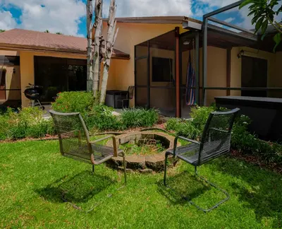two chairs sitting in the grass in a yard at Luxury Queen Room, Free Car Service, Walk to UM! in Miami