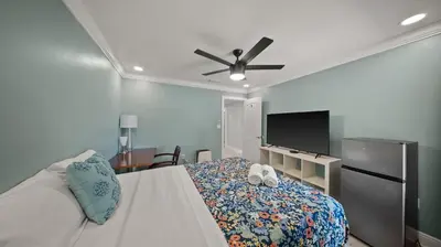 a bedroom with a bed and a flat screen tv at Luxury Queen Room, Free Car Service, Walk to UM! in Miami