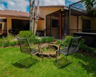 two chairs sitting in the grass in a yard at Large Private Room, Free Car Service, Walk to UM! in Miami