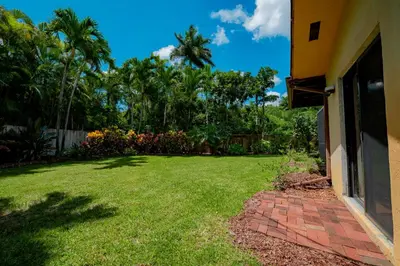 a yard next to a house with a lawn at Large Private Room, Free Car Service, Walk to UM! in Miami