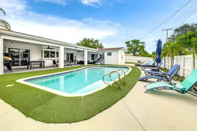 a swimming pool with two chairs and a house at Outdoor Oasis with Games Sleek Hollywood Home! in Hollywood