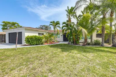 a house with palm trees in front of a yard at Outdoor Oasis with Games Sleek Hollywood Home! in Hollywood