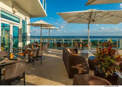 a patio with chairs and tables and umbrellas at MVR - A Suite That-s Actually as Good as It Looks in Miami