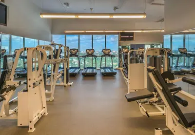 a gym with rows of tread machines and windows at MVR Designer Suite with Balcony and Miami-s Best Views in Miami