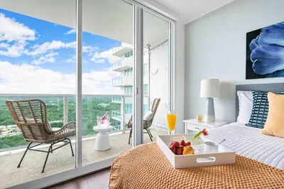 a bedroom with a bed and a balcony with a view at MVR Suite with Poolside Sips and Biscayne Backdrop in Miami