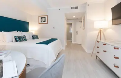 a white bedroom with a bed and a table at MVR Suite with Access to Miami-s Best Rooftop in Miami