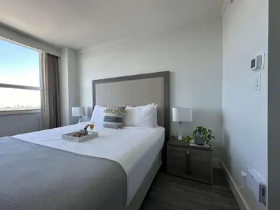 a white bedroom with a large bed with a tray on it at MVR Suite Boutique Living with Big Luxury Energy in Miami