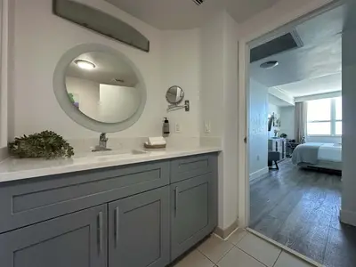 a bathroom with a sink and a mirror and a bedroom at MVR Suite Boutique Living with Big Luxury Energy in Miami