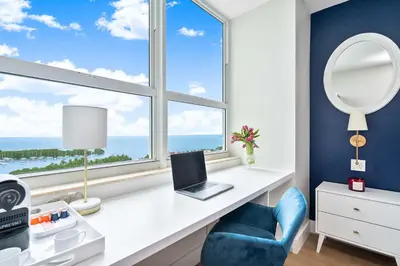 a desk with a laptop and a chair in front of a window at MVR Suite The Secret to Luxury Living Is Right Here in Miami