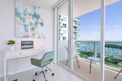 an office with a desk and a computer and a balcony at MVR Biscayne Bay Views That Stun Daily in Miami