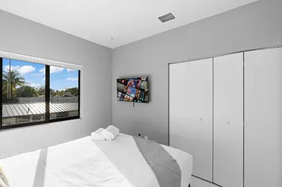 a white bedroom with a bed and a window at Spacious 4-BR House W Free Parking in Miami
