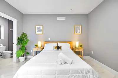 a bedroom with a large white bed with two night stands at Comfy Studio W Beautiful Space! in Miami