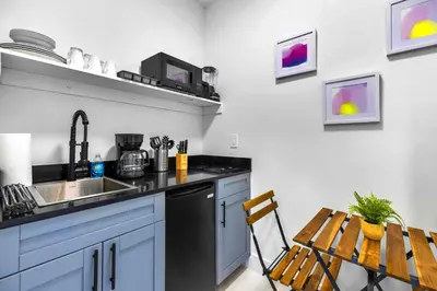 a kitchen with a sink and a table with a chair at Comfy Studio W Beautiful Space! in Miami