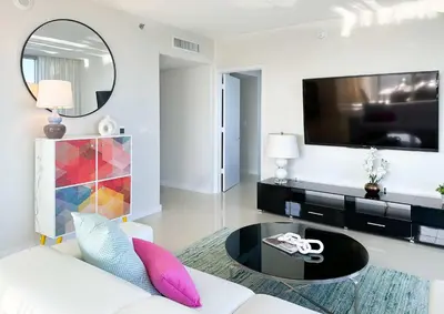 a living room with a white couch and a large tv at MVR An Unforgettable View Awaits You in Miami
