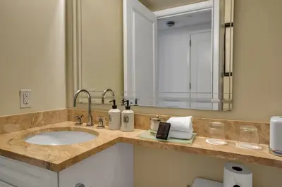 a bathroom with a sink and a large mirror at Four Seasons Miami Two Bedroom - 2Bath Ocean view Suite - Amazing views in Miami
