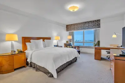 a hotel room with a bed and a desk and a window at Four Seasons Miami Two Bedroom - 2Bath Ocean view Suite - Amazing views in Miami