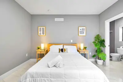 a white bedroom with a large bed and a toilet at Studio in Miami - Ideal for Couples & Travelers in Miami