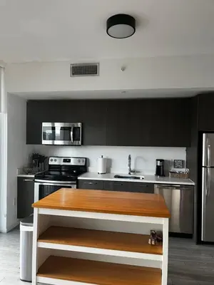 a kitchen with black cabinets and a wooden counter top at Luxury Studio in Miami
