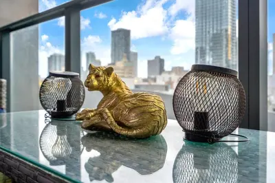 a statue of a cat sitting on a table with two vases at Best Location 2 bedrooms 2 bathrooms in Miami