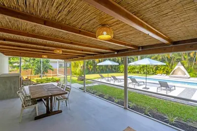 a patio with a table and chairs and a pool at 4BR Biscayne River Home- Pool & Pickleball Fun home in Miami