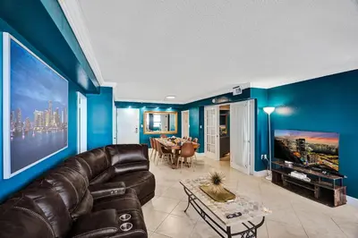 a living room with a leather couch and blue walls at Cozy 2BR Condo with Resort Perks Pools Gym Sauna in an Oceanfront Building 409 in Miami Beach