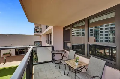 a balcony with a table and chairs on a building at Cozy 2BR Condo with Resort Perks Pools Gym Sauna in an Oceanfront Building 409 in Miami Beach