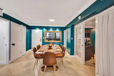 a dining room with blue walls and a table and chairs at Cozy 2BR Condo with Resort Perks Pools Gym Sauna in an Oceanfront Building 409 in Miami Beach