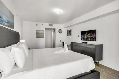 a white bedroom with a large bed with white pillows at Stylish 1BR Brickell Retreat Walk to Everything in Miami