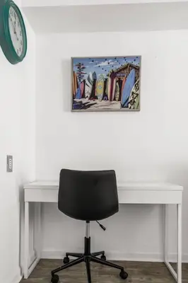 a desk with a chair and a clock on a wall at Stylish 1BR Brickell Retreat Walk to Everything in Miami