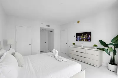 a white bedroom with a white bed and a tv at Icon Brickell 2BR Poolside Paradise in the Sky in Miami