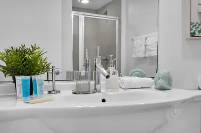 a white bathroom with a sink and a mirror at Icon Brickell 2BR Poolside Paradise in the Sky in Miami