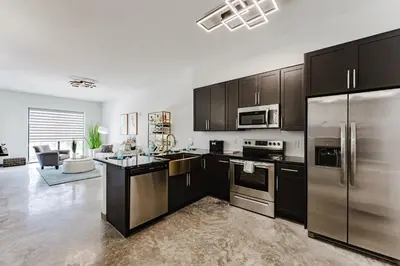 a kitchen with black cabinets and stainless steel appliances at Miami apartment style - Casino & Restaurants in Fort Lauderdale