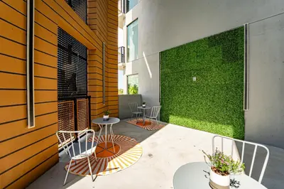 a patio with chairs and tables and a green wall at Miami apartment style - Casino & Restaurants in Fort Lauderdale