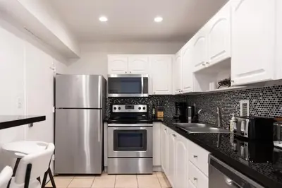 a kitchen with white cabinets and a stainless steel refrigerator at Beachfront 2 BR Apt Full Kitchen - No Resort Fee in Hollywood