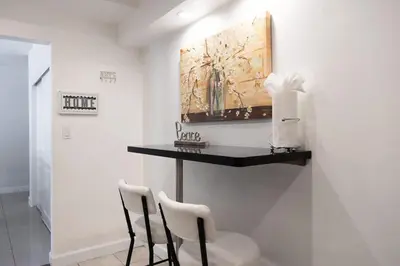 a room with two chairs and a table and a painting at Beachfront 2 BR Apt Full Kitchen - No Resort Fee in Hollywood